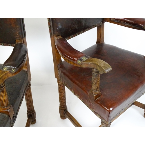 1863 - A pair of late 19thC / early 20thC leather upholstered armchairs with swept arms and brass detailing... 