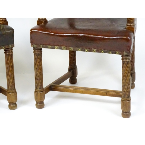 1863 - A pair of late 19thC / early 20thC leather upholstered armchairs with swept arms and brass detailing... 