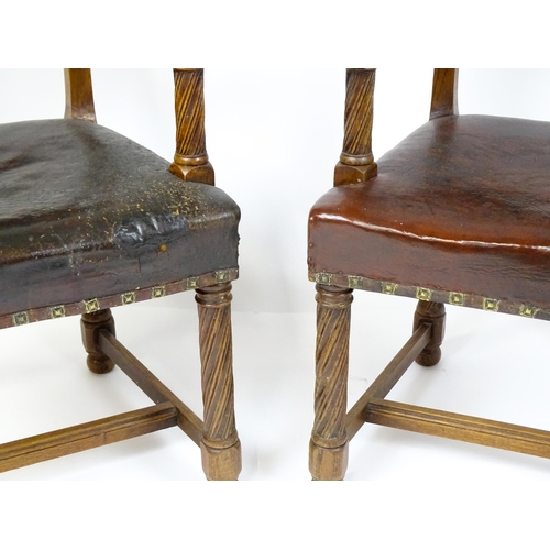 1863 - A pair of late 19thC / early 20thC leather upholstered armchairs with swept arms and brass detailing... 