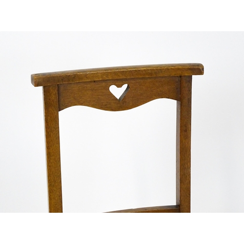 1865 - A pair of Arts & Crafts oak side chairs with shaped top rails pierced with heart motifs, the chairs ... 