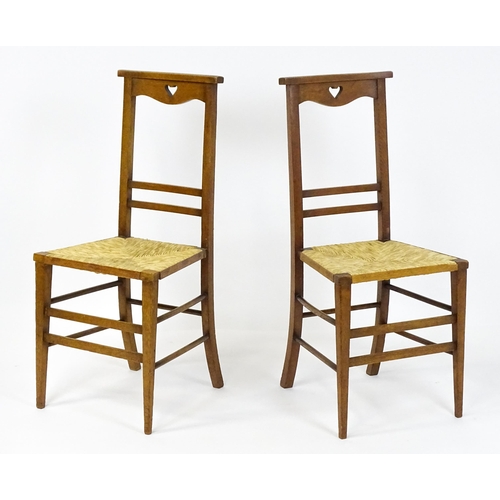 1865 - A pair of Arts & Crafts oak side chairs with shaped top rails pierced with heart motifs, the chairs ... 