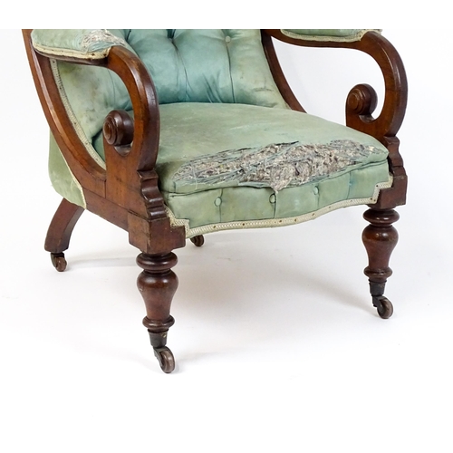 1899 - A Victorian mahogany armchair with a scrolled and deep buttoned backrest above manchettes and a spru... 