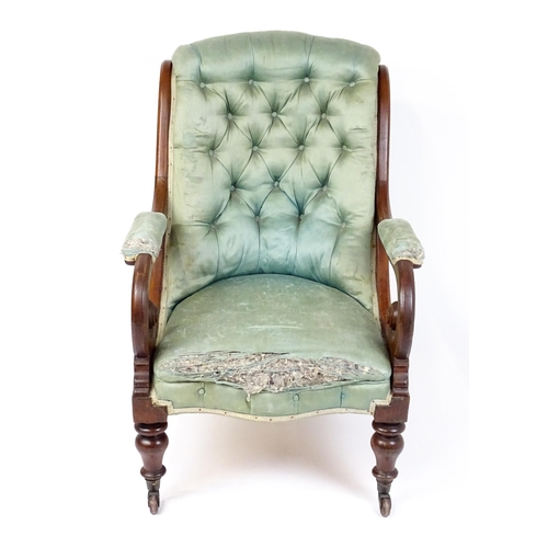 1899 - A Victorian mahogany armchair with a scrolled and deep buttoned backrest above manchettes and a spru... 