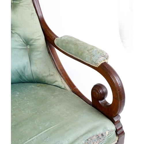 1899 - A Victorian mahogany armchair with a scrolled and deep buttoned backrest above manchettes and a spru... 