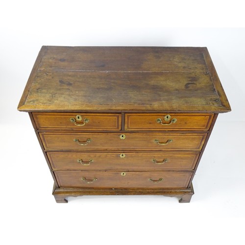 1752 - An 18thC oak chest of drawers with a moulded top above two short over three long drawers with crossb... 