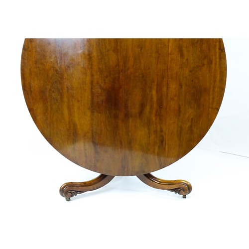 1895 - A Victorian mahogany breakfast / dining table with a round tilt op above a turned pedestal raised on... 