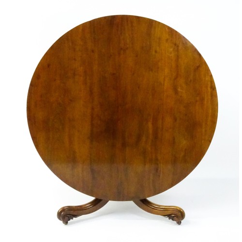 1895 - A Victorian mahogany breakfast / dining table with a round tilt op above a turned pedestal raised on... 