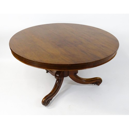 1895 - A Victorian mahogany breakfast / dining table with a round tilt op above a turned pedestal raised on... 