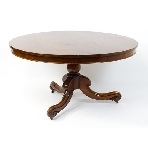 1895 - A Victorian mahogany breakfast / dining table with a round tilt op above a turned pedestal raised on... 