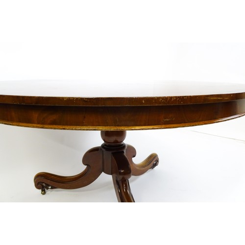 1895 - A Victorian mahogany breakfast / dining table with a round tilt op above a turned pedestal raised on... 