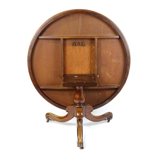 1895 - A Victorian mahogany breakfast / dining table with a round tilt op above a turned pedestal raised on... 