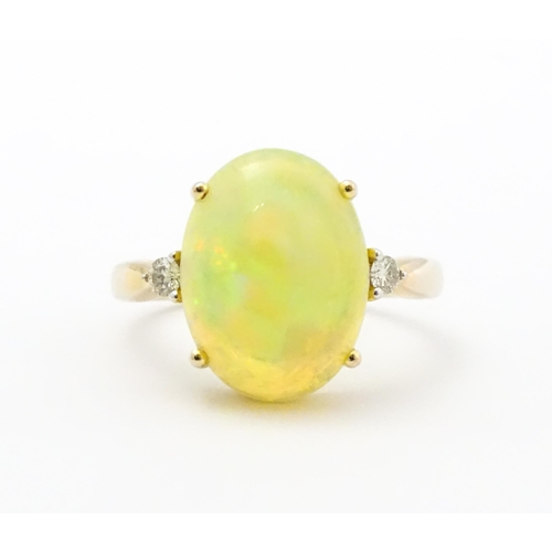 837 - A 9ct gold ring set with central opal cabochon flanked by diamonds. Ring size approx. P