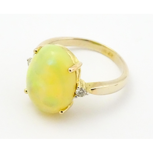 837 - A 9ct gold ring set with central opal cabochon flanked by diamonds. Ring size approx. P