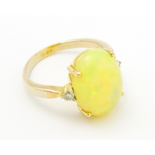 837 - A 9ct gold ring set with central opal cabochon flanked by diamonds. Ring size approx. P