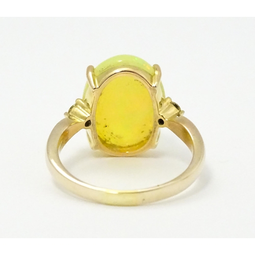 837 - A 9ct gold ring set with central opal cabochon flanked by diamonds. Ring size approx. P