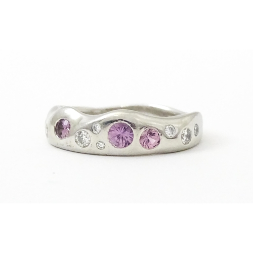 856 - A platinum ring set with pink sapphires and diamonds. Ring size approx. J 1/2