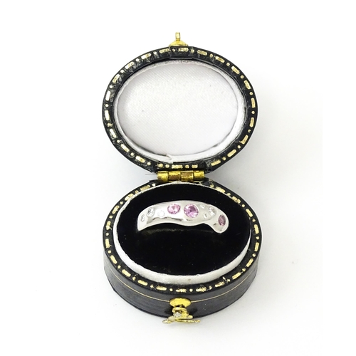 856 - A platinum ring set with pink sapphires and diamonds. Ring size approx. J 1/2