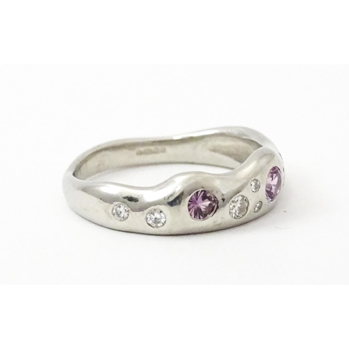 856 - A platinum ring set with pink sapphires and diamonds. Ring size approx. J 1/2