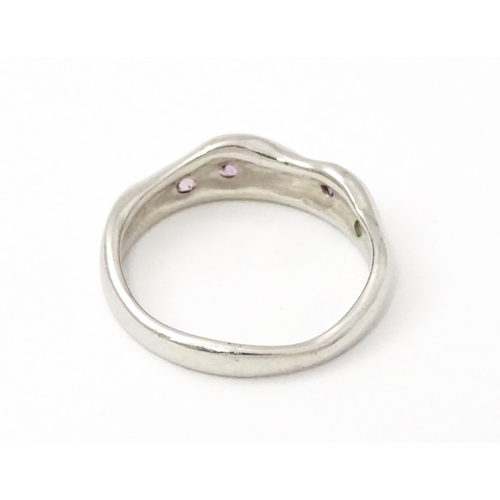 856 - A platinum ring set with pink sapphires and diamonds. Ring size approx. J 1/2