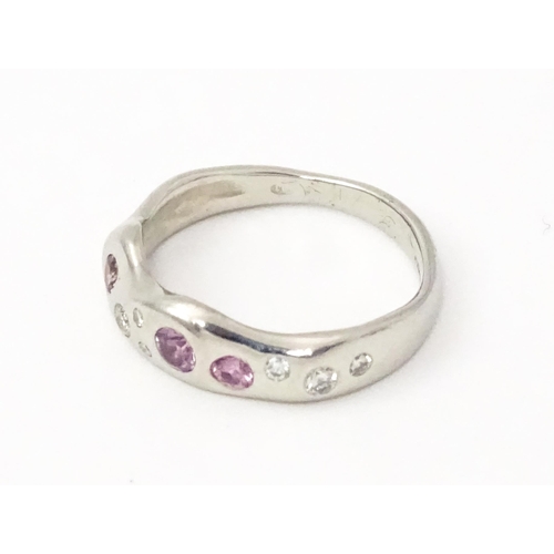 856 - A platinum ring set with pink sapphires and diamonds. Ring size approx. J 1/2