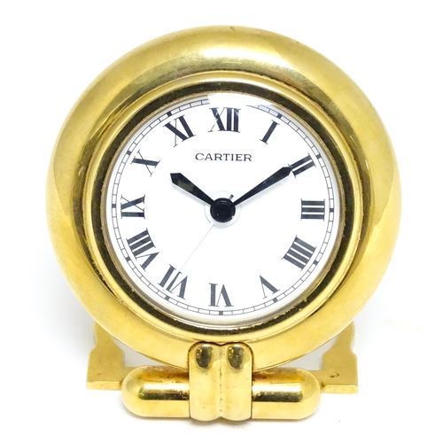 1658 - A Cartier brass cased alarm clock with quartz movement, the white dial with Roman numerals and signe... 