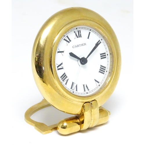 1658 - A Cartier brass cased alarm clock with quartz movement, the white dial with Roman numerals and signe... 