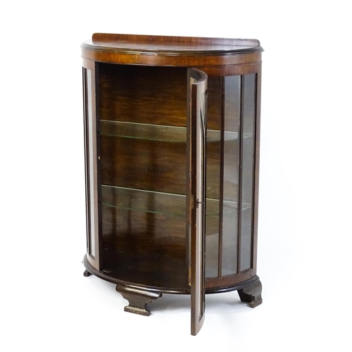 1735 - An early / mid 20thC walnut display cabinet with an upstand above an astragal glazed door raised on ... 