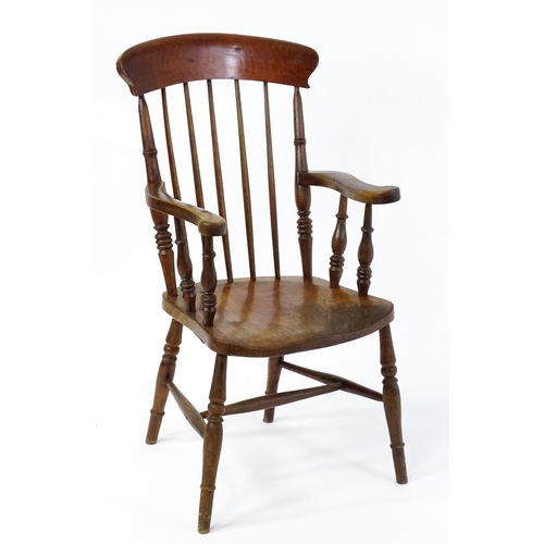 1868 - A late 19thC stick back Windsor chair with swept arms, a shaped elm seat and raised on four turned t... 