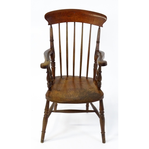 1868 - A late 19thC stick back Windsor chair with swept arms, a shaped elm seat and raised on four turned t... 