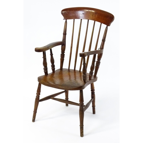 1868 - A late 19thC stick back Windsor chair with swept arms, a shaped elm seat and raised on four turned t... 