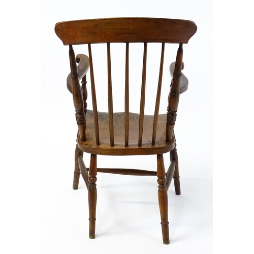 1868 - A late 19thC stick back Windsor chair with swept arms, a shaped elm seat and raised on four turned t... 