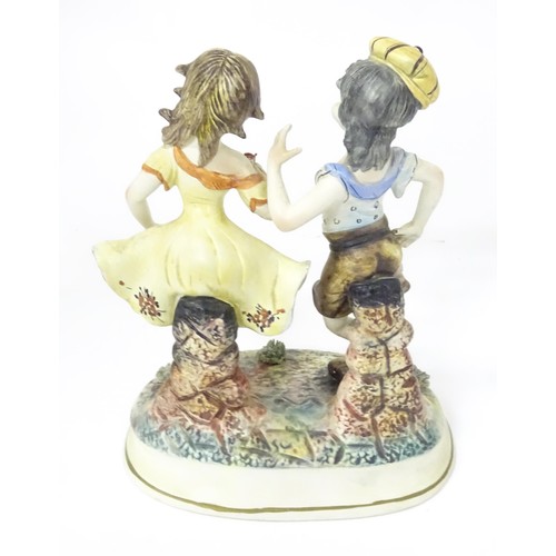 778 - A Capodimonte figural group depicting a boy and girl dancing. Approx. 10 1/2