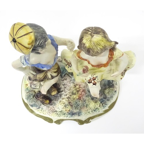 778 - A Capodimonte figural group depicting a boy and girl dancing. Approx. 10 1/2