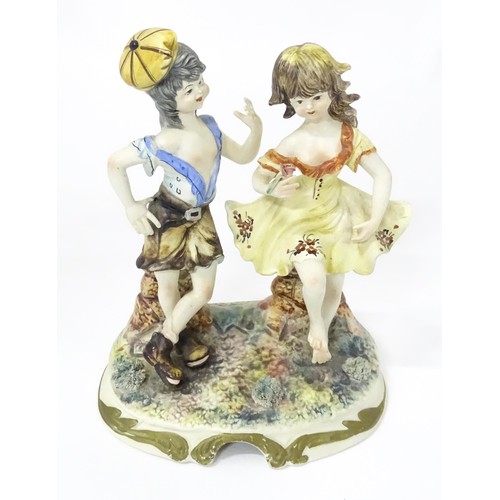 778 - A Capodimonte figural group depicting a boy and girl dancing. Approx. 10 1/2