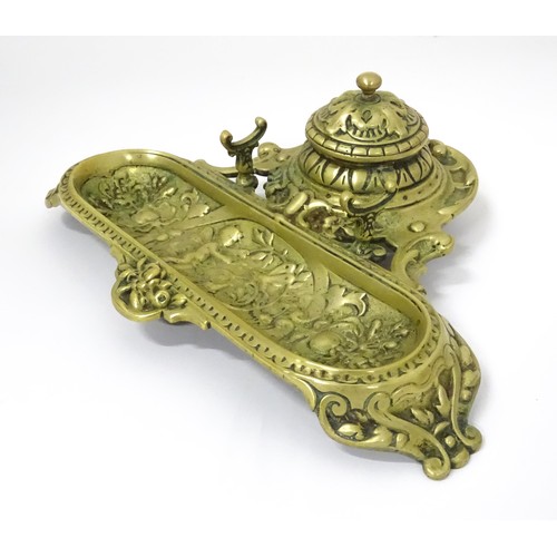 783 - An early 20thC brass standish with inkwell and pen rest and tray, stamped 6899 underside, approx 11