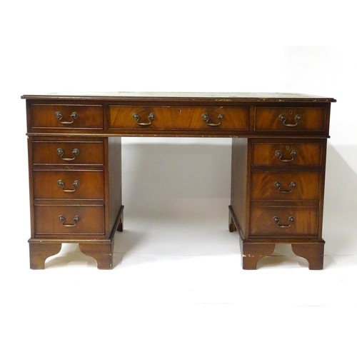 844 - A late 20thC mahogany pedestal desk, with green leather inset top and comprising three drawers over ... 