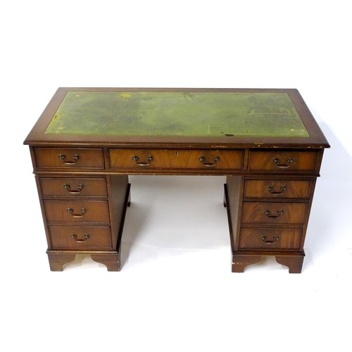 844 - A late 20thC mahogany pedestal desk, with green leather inset top and comprising three drawers over ... 