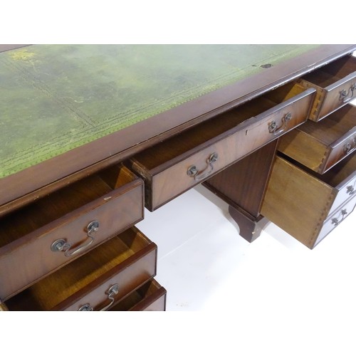 844 - A late 20thC mahogany pedestal desk, with green leather inset top and comprising three drawers over ... 