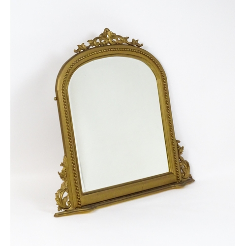 865 - A modern mahogany mirror with a gilt finish, surmounted by a pierced, floral moulding and having mat... 