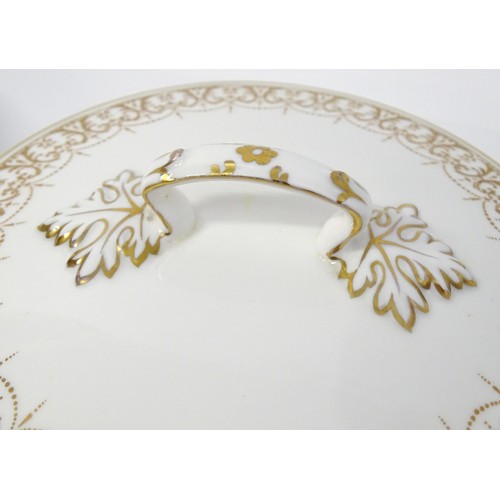 878 - A quantity of Crown Staffordshire dinner wares with gilt borders to include tureens, serving plates,... 