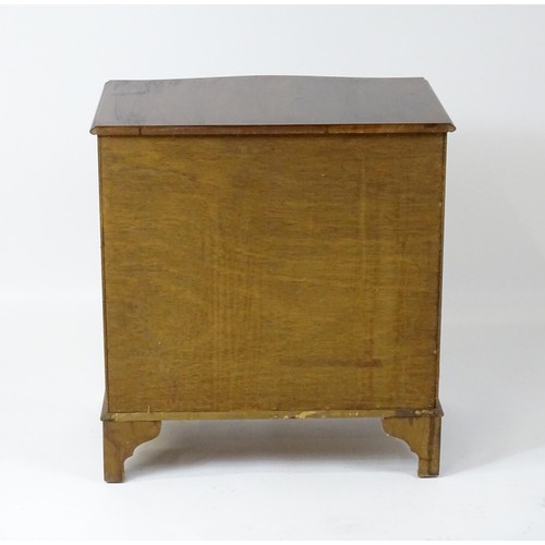 32A - A late 20thC mahogany serpentine fronted chest with a brushing slide, above a hinged door raised on ... 