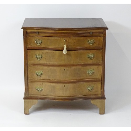 32A - A late 20thC mahogany serpentine fronted chest with a brushing slide, above a hinged door raised on ... 