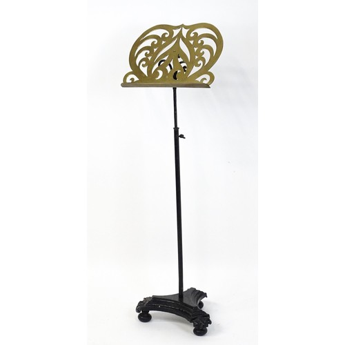 1578 - A Victorian music stand, the brass page rest formed as a lyre and supported by a painted wrought iro... 