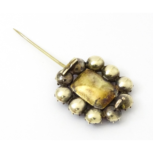 978 - Mourning / Memorial Jewellery: A 19thC yellow metal mourning brooch set with central locket bordered... 