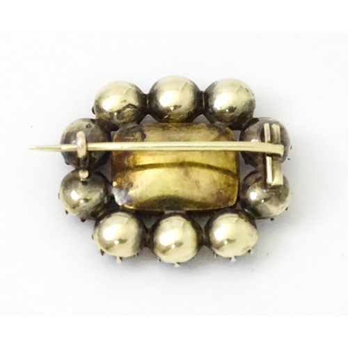 978 - Mourning / Memorial Jewellery: A 19thC yellow metal mourning brooch set with central locket bordered... 