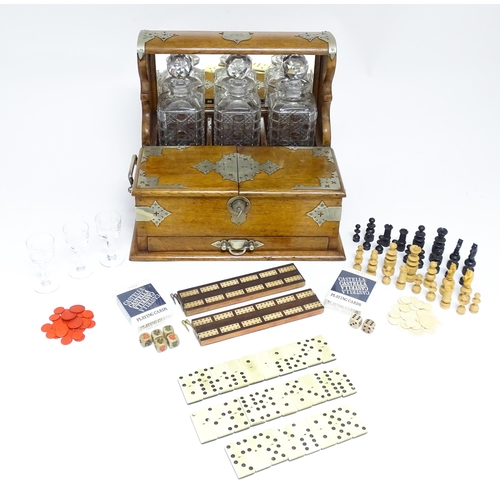 1532 - A Victorian oak tantalus / games compendium with silver plate mounts. With three glass decanters and... 