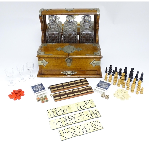 1532 - A Victorian oak tantalus / games compendium with silver plate mounts. With three glass decanters and... 