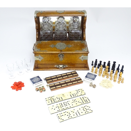 1532 - A Victorian oak tantalus / games compendium with silver plate mounts. With three glass decanters and... 