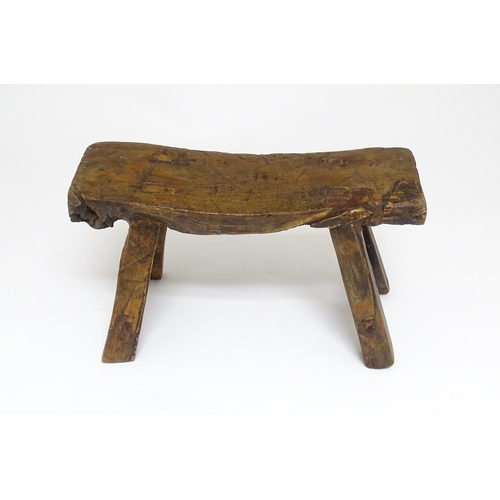 1739 - A 19thC oak country made small milking stool, the seat of rectangular form supported by four splayed... 