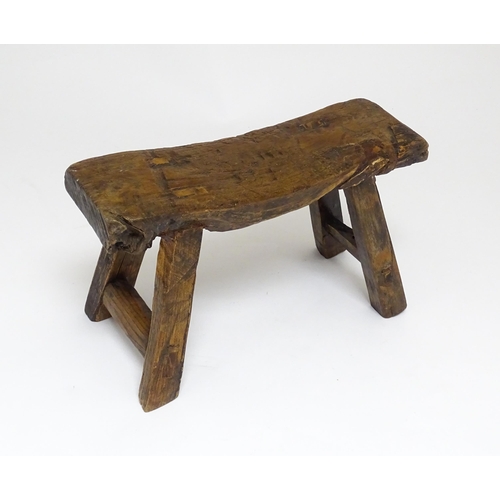 1739 - A 19thC oak country made small milking stool, the seat of rectangular form supported by four splayed... 